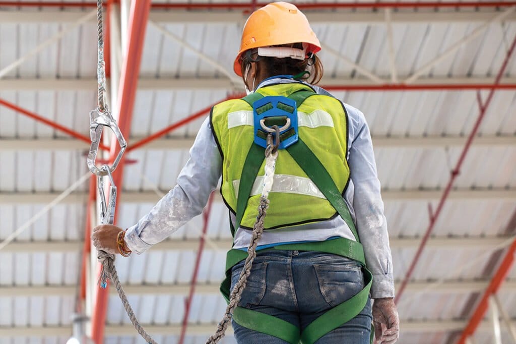 Worker in harness using fall protection.