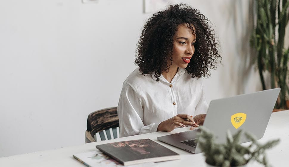 Woman working on laptop at desk.