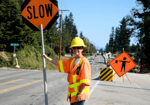 Woman holding slow sign at road construction.