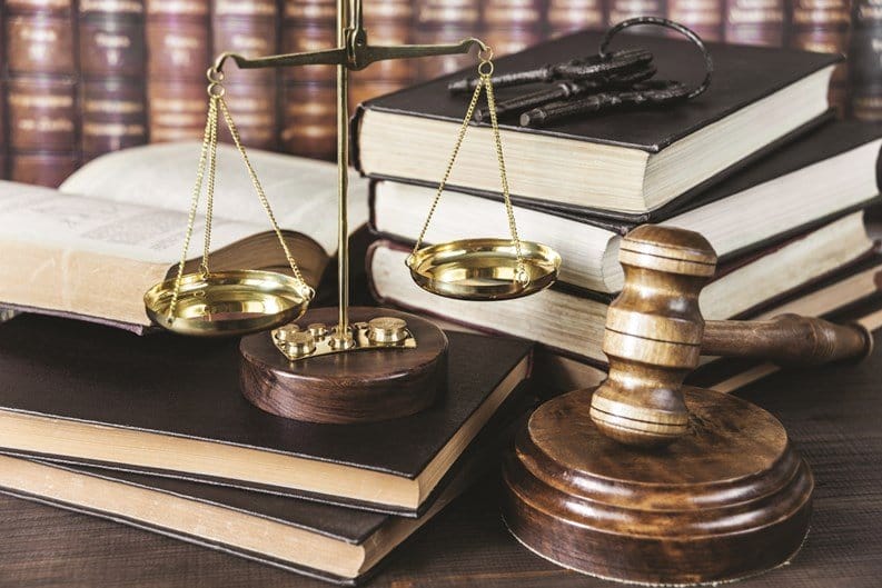 Scales of justice, gavel, legal books.
